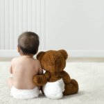 bebé y osito de peluche