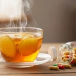 Taza de té humeante con jengibre y miel, frasco de vitaminas